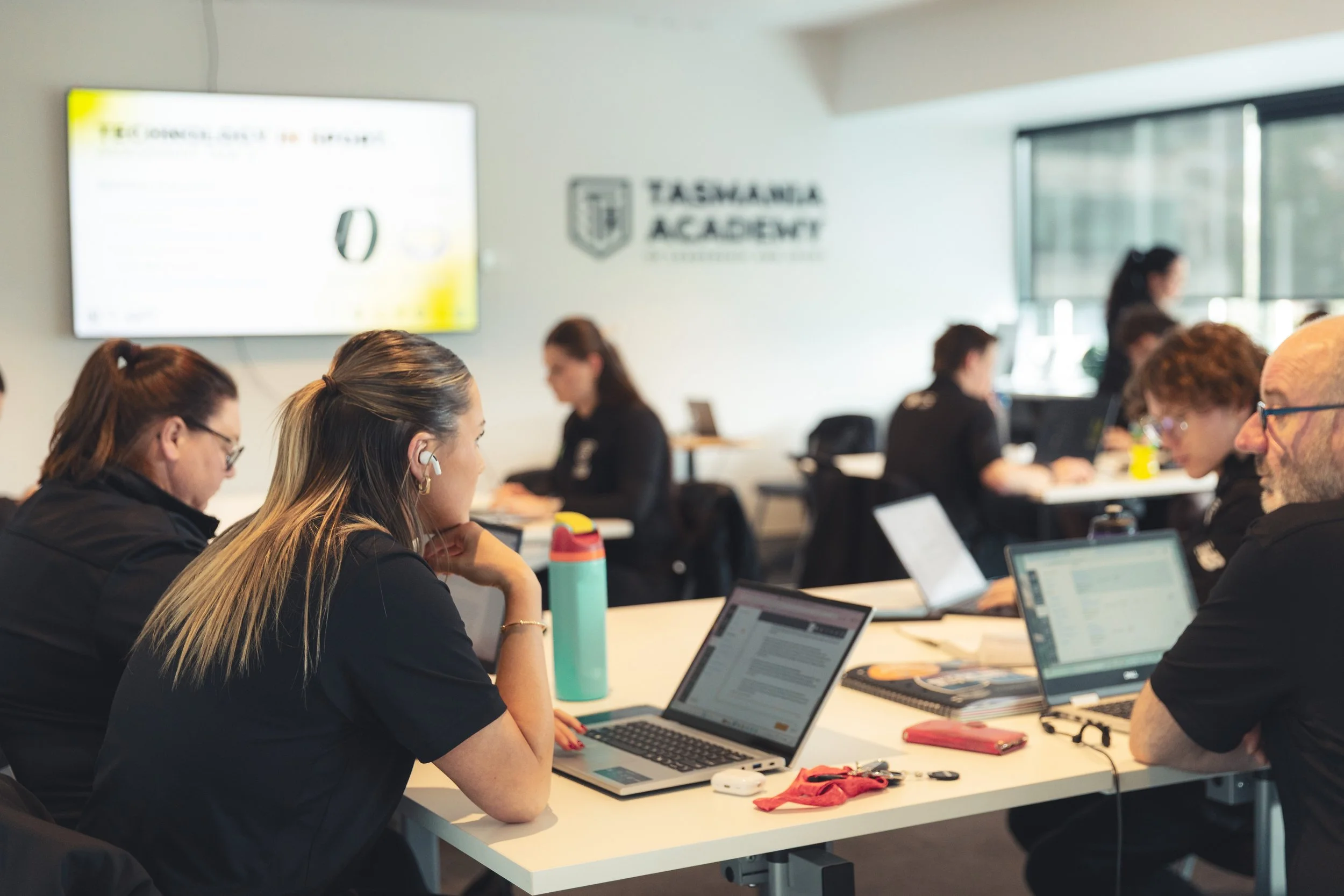 Students collaborating with laptops at a Tasmanian Academy classroom table