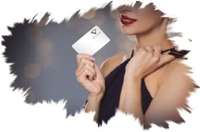 A woman holding a white credit card, smiling, with her face partially visible and a black strap dress.
