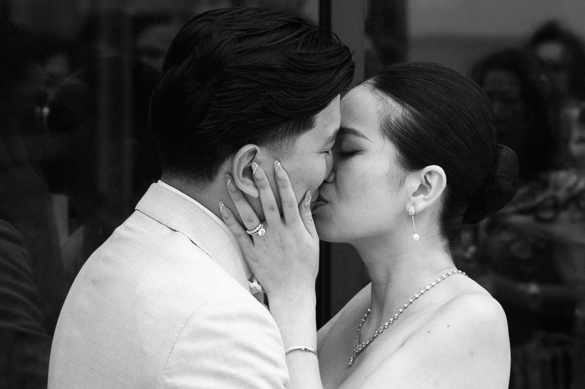 Black-and-white close-up of a couple kissing, with the woman holding the man's face.