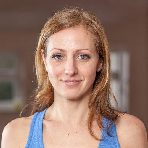 Smiling woman with long light brown hair wearing a blue tank top