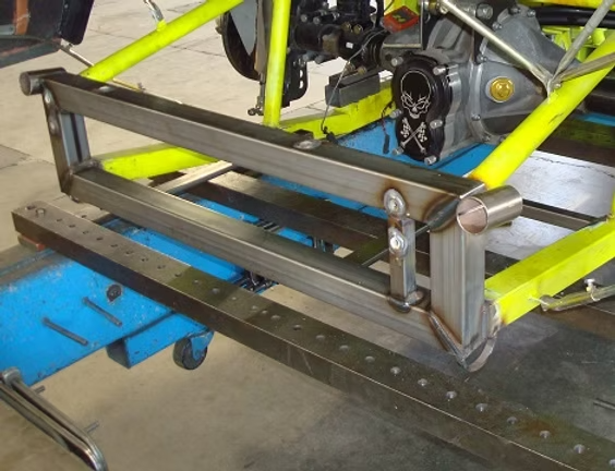 Close-up of a custom metal chassis frame with engine and welded structural brackets