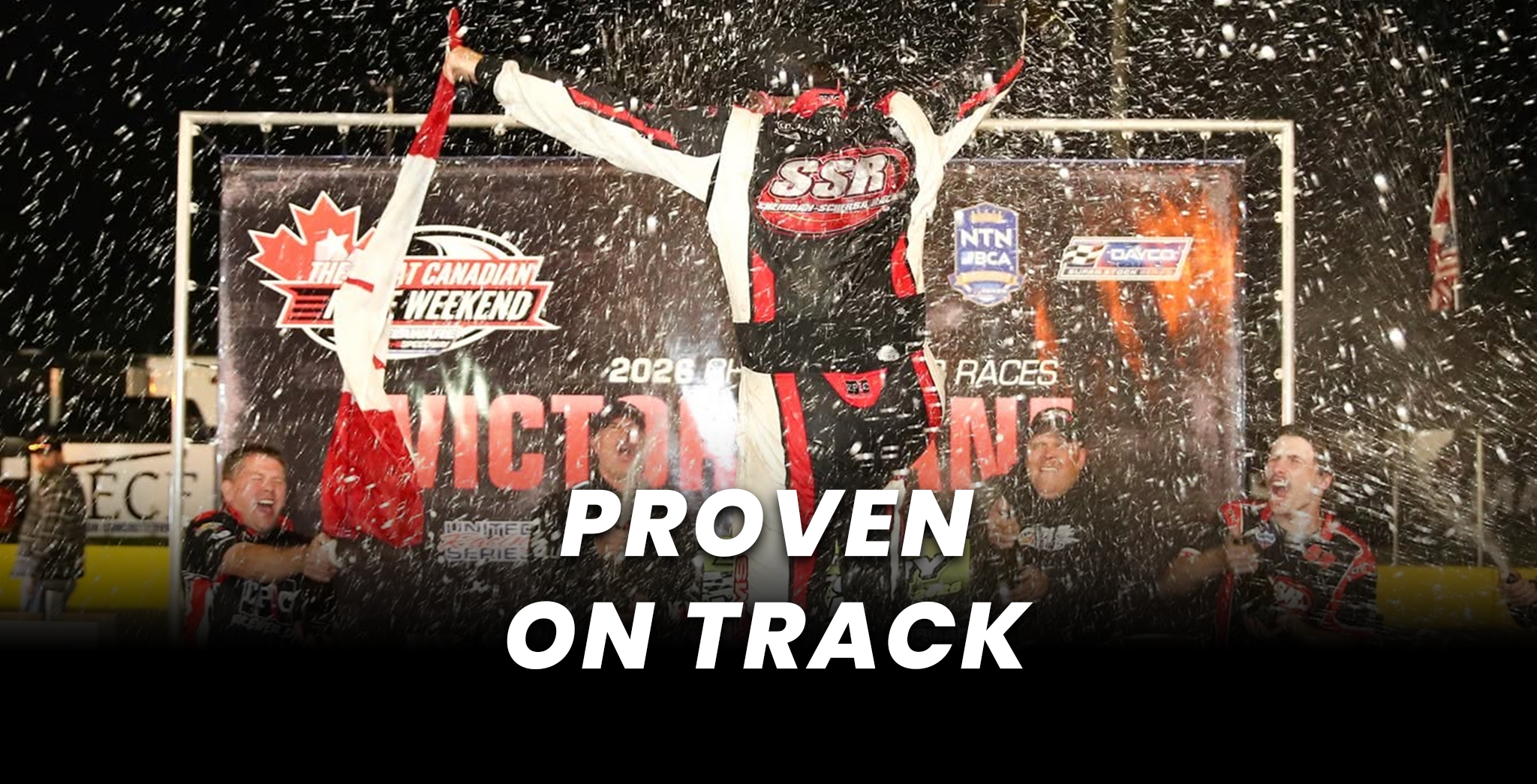 Snowmobile racer celebrating on a podium with teammates amid falling snow, Canadian snowmobile racing event backdrop, and “Proven on Track” text.