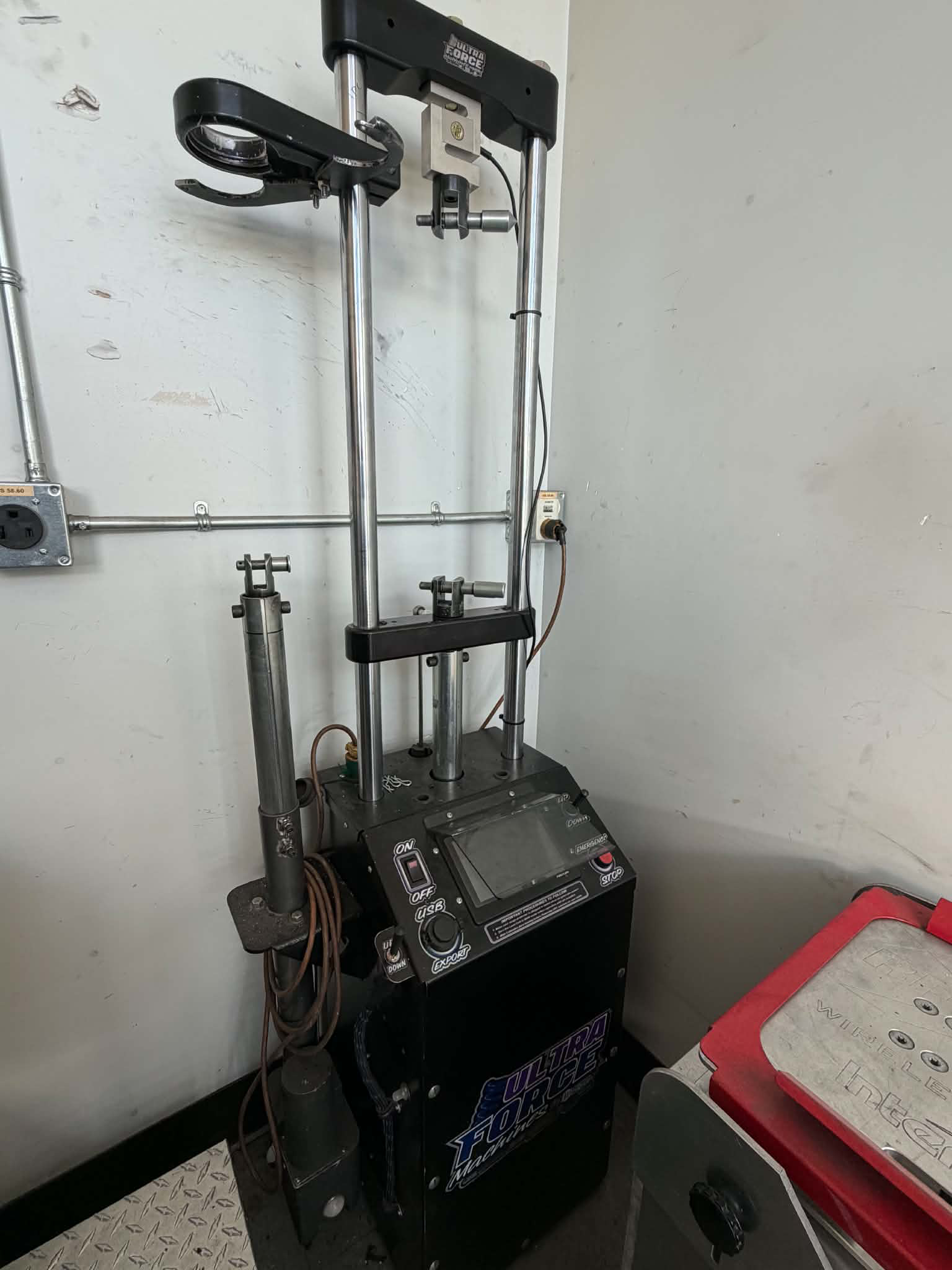 Miller tire changer machine with vertical mounting posts, control panel, and tire-handling attachments in an auto repair shop.