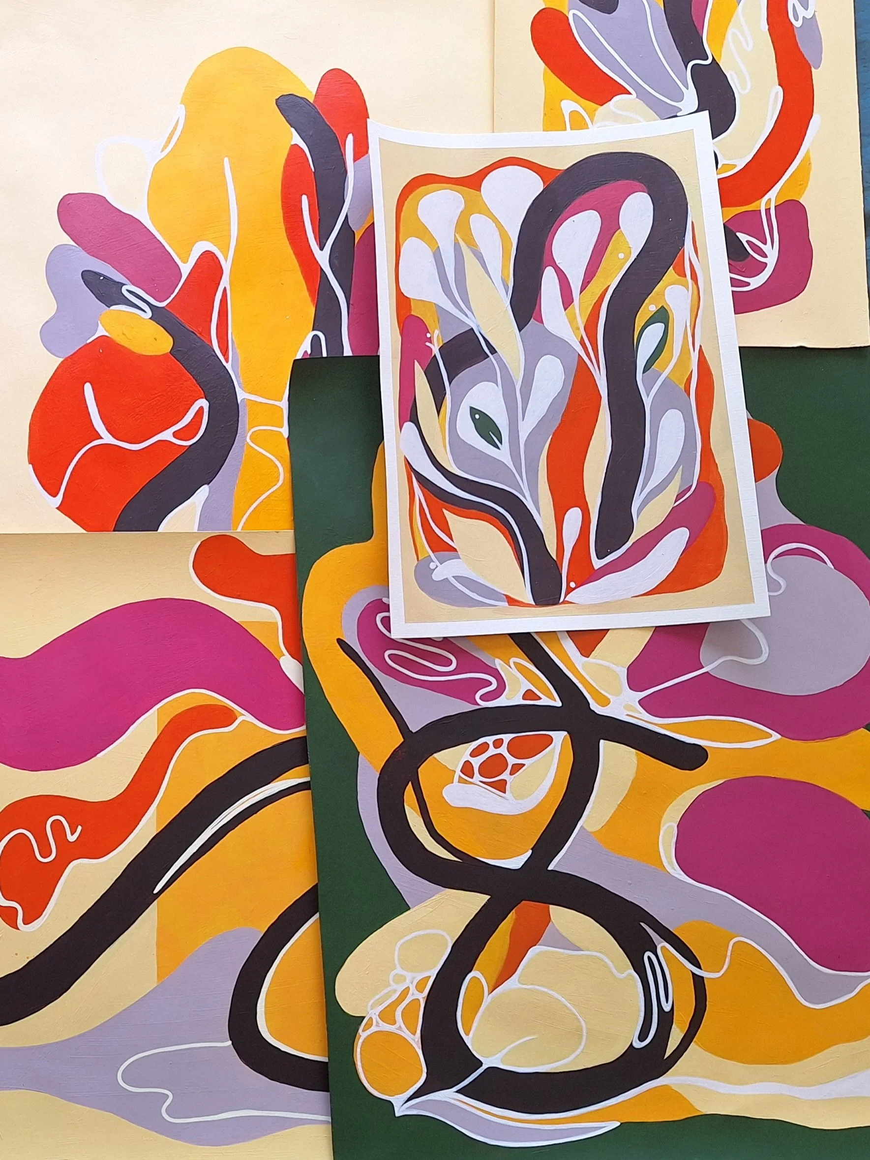 Composition de peintures abstraites colorées aux formes organiques, avec une œuvre encadrée au premier plan.