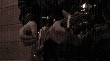Close-up of person playing an electric guitar.