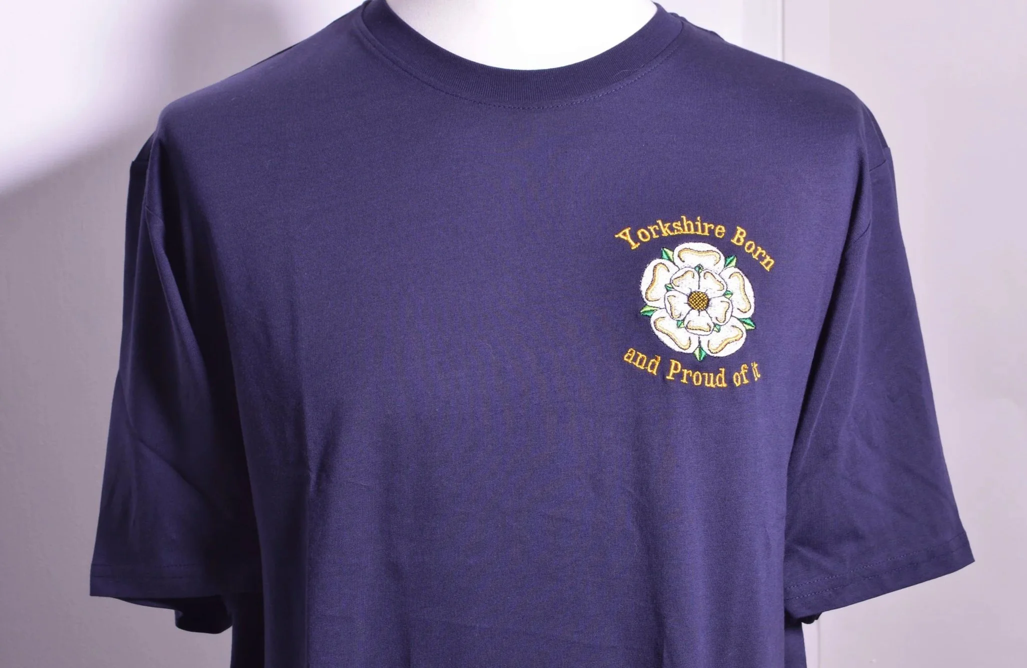 A purple long-sleeve shirt with embroidered design and text that reads "Yorkshire Born and Proud of it."