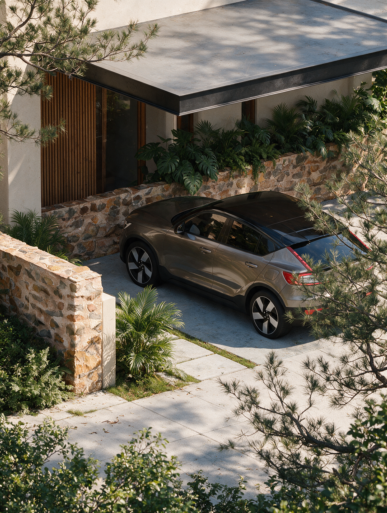 Garagem com carro cinza escuro estacionado, muro de pedra e plantas ao redor de uma casa moderna com teto de concreto e persianas de madeira.