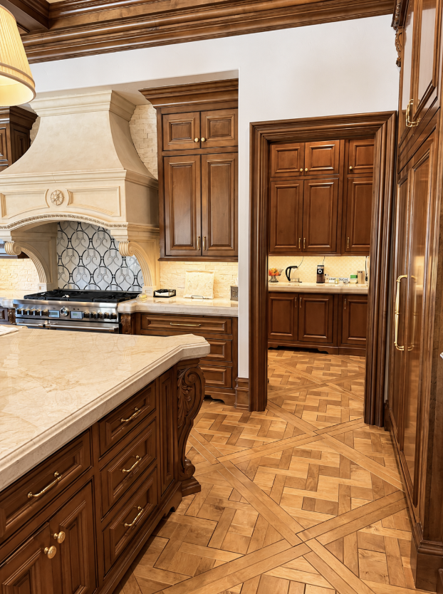 Spacious, well-maintained kitchen featuring rich wood cabinetry, marble countertops, and a separate prep area with clear, organized surfaces