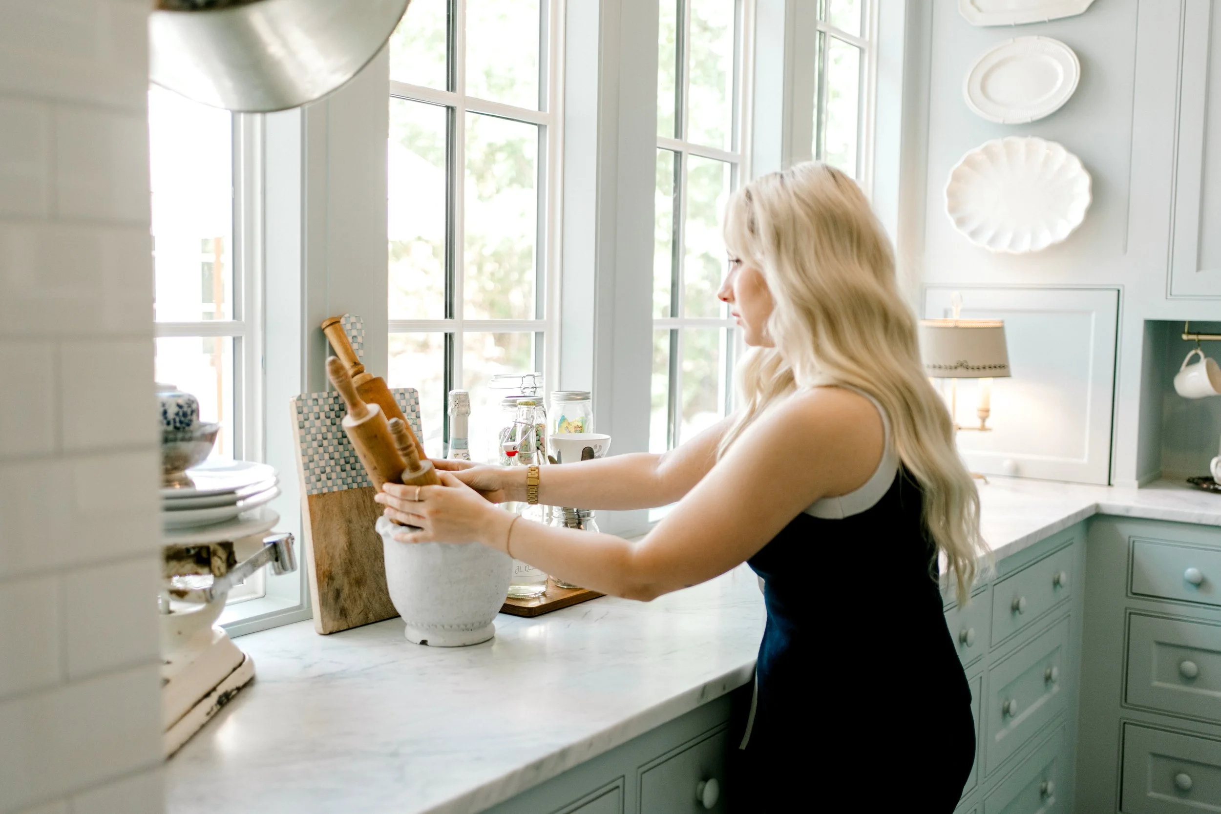 Professional home organizer styling kitchen countertops and arranging decorative accessories as part of OrganizePro's white-glove organizing services.