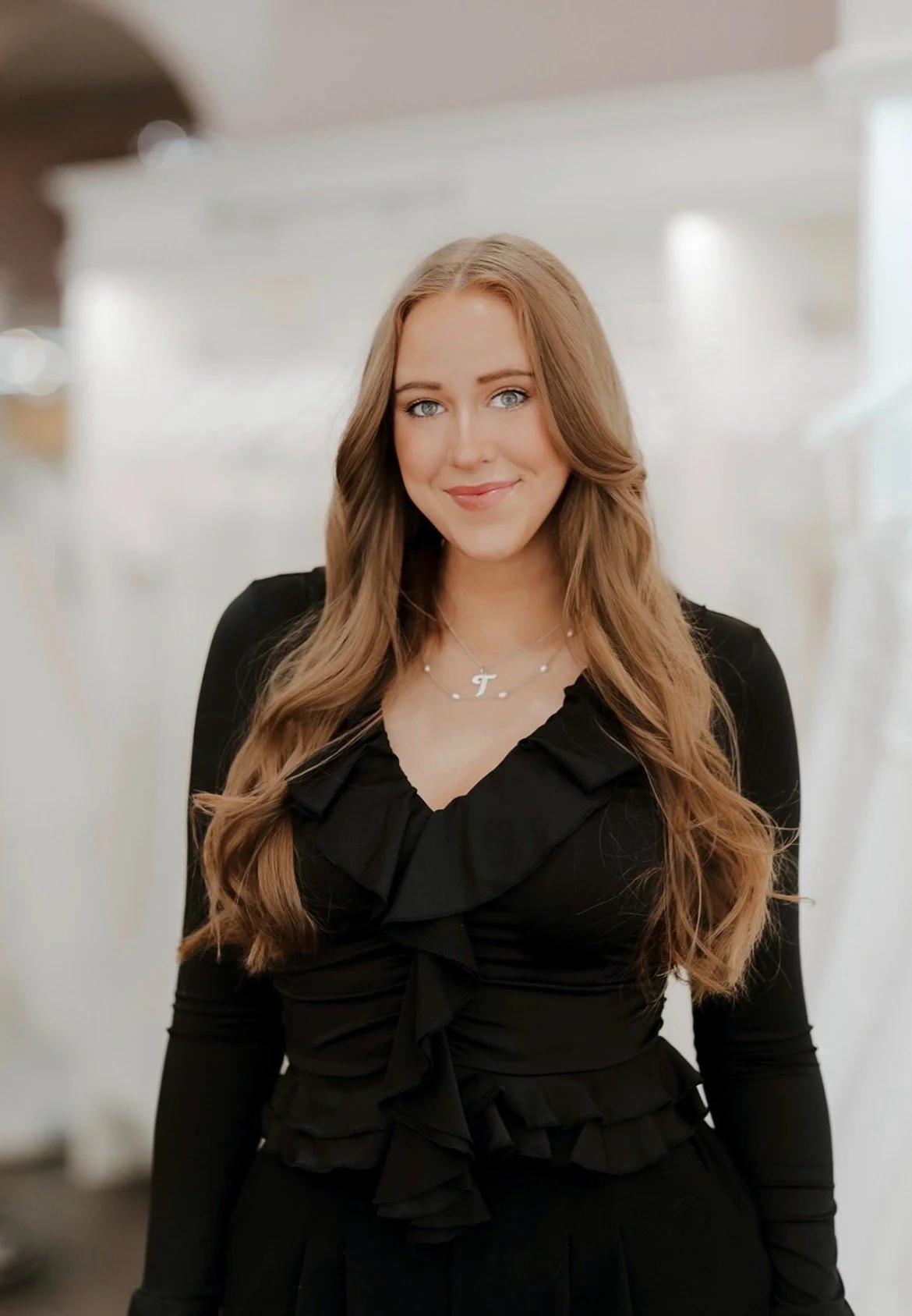 Trish, professional home organizer at OrganizePro, smiling in a black top for her team portrait.