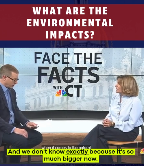 A TV studio with a large screen displaying the words 'What are the environmental impacts? Face the Facts with NBC', and two people sitting and having a discussion, with a city building in the background on the screen.