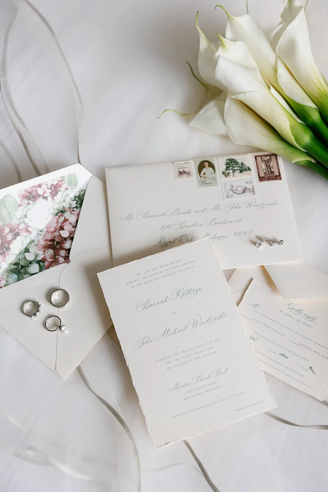 Elegant wedding invitation suite with white calla lilies, vintage postage stamps, silver wedding rings, floral card, and RSVP card