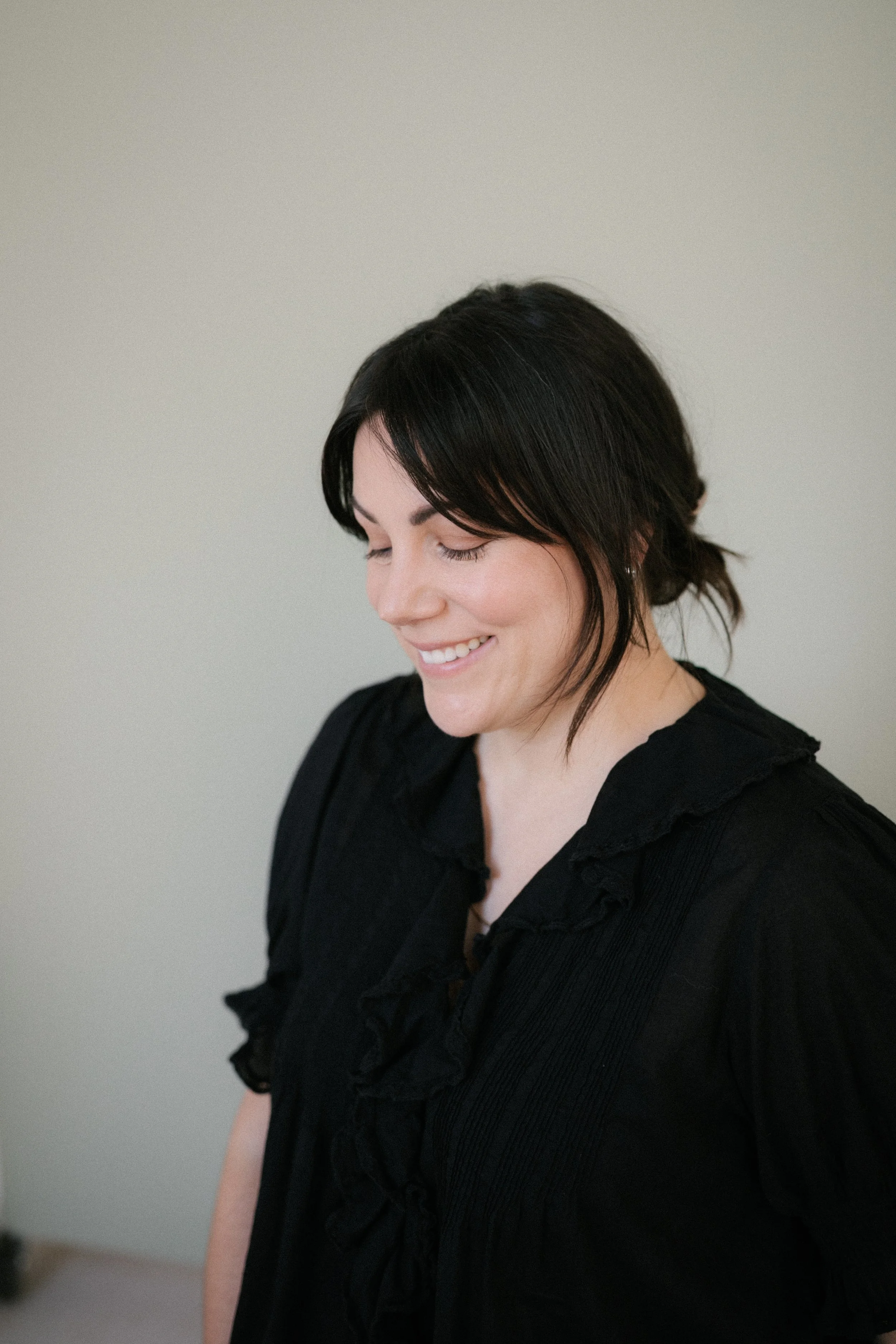 Smiling woman with dark hair wearing a black top