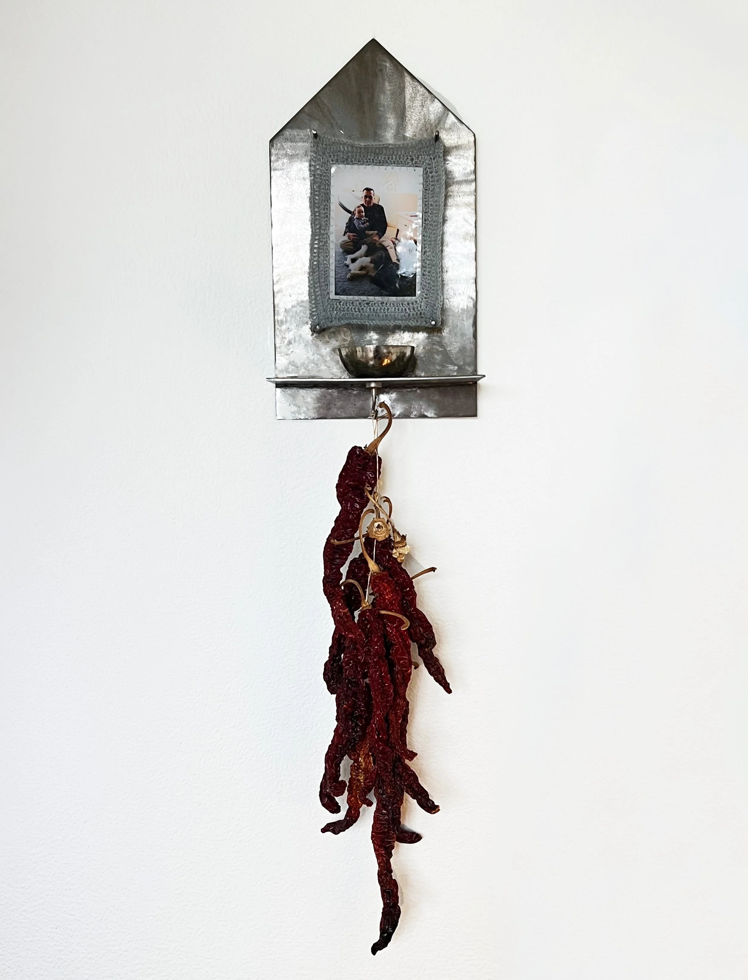 I Love You, Yes I Do, 2025. Welded steel, family image printed on photo paper, mohair yarn crochet border, red peppers dried and strung by grandfather.
