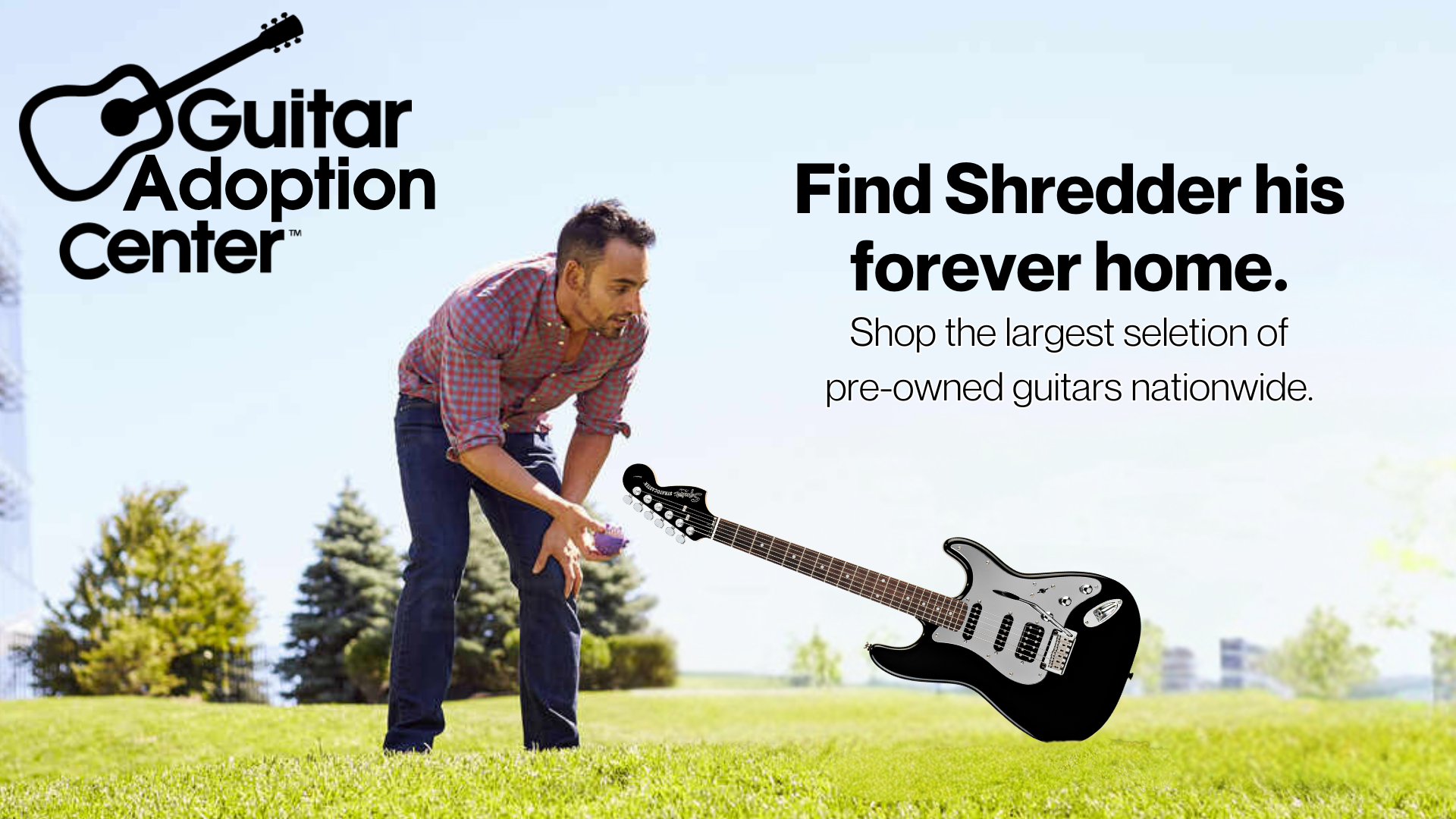 A man in a checkered shirt and jeans bending down outdoors to pick up a purple guitar pick. There is a black and silver electric guitar floating in the air nearby, with trees and a clear sky in the background. Text on the image reads 'Guitar Adoption Center' and 'Find Shredder his forever home. Shop the largest selection of pre-owned guitars nationwide.'