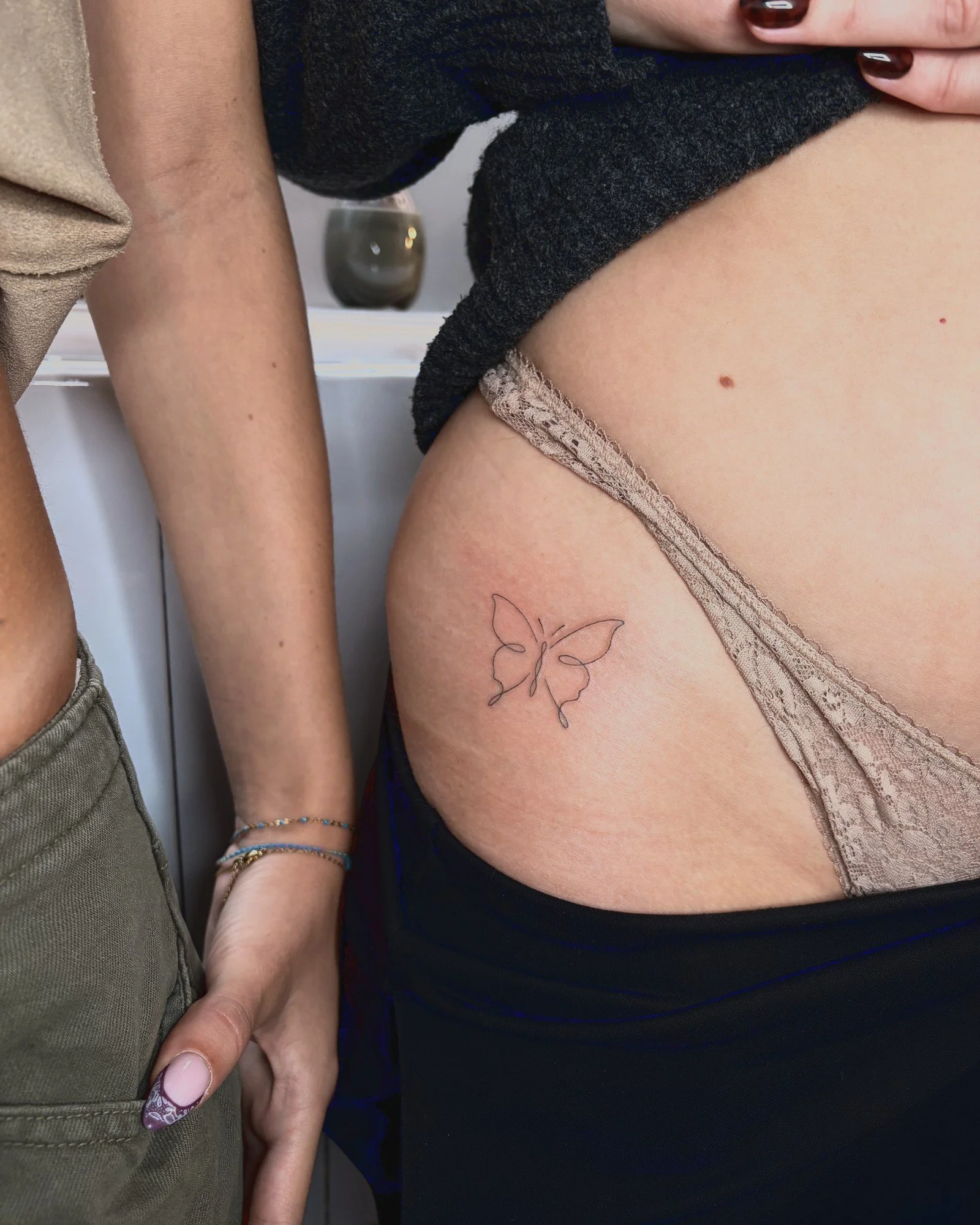 Tatouage fine line d'un papillon sur la hanche, réalisé par Finime à Lyon