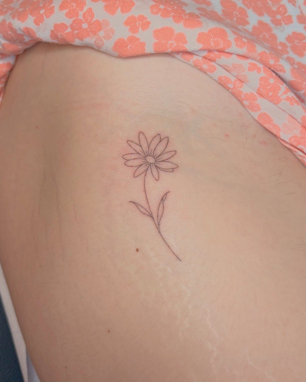 Marguerite fine line tatouée sur la cuisse, par Finime à Lyon