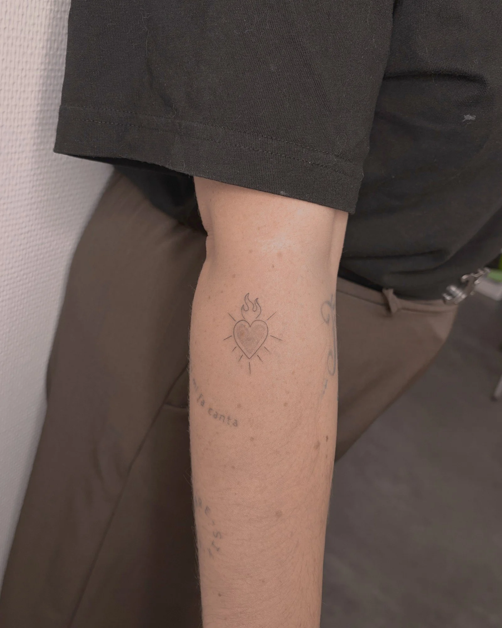 Tatouage fine line d'un cœur sacré sur le bras, réalisé par Finime à Lyon