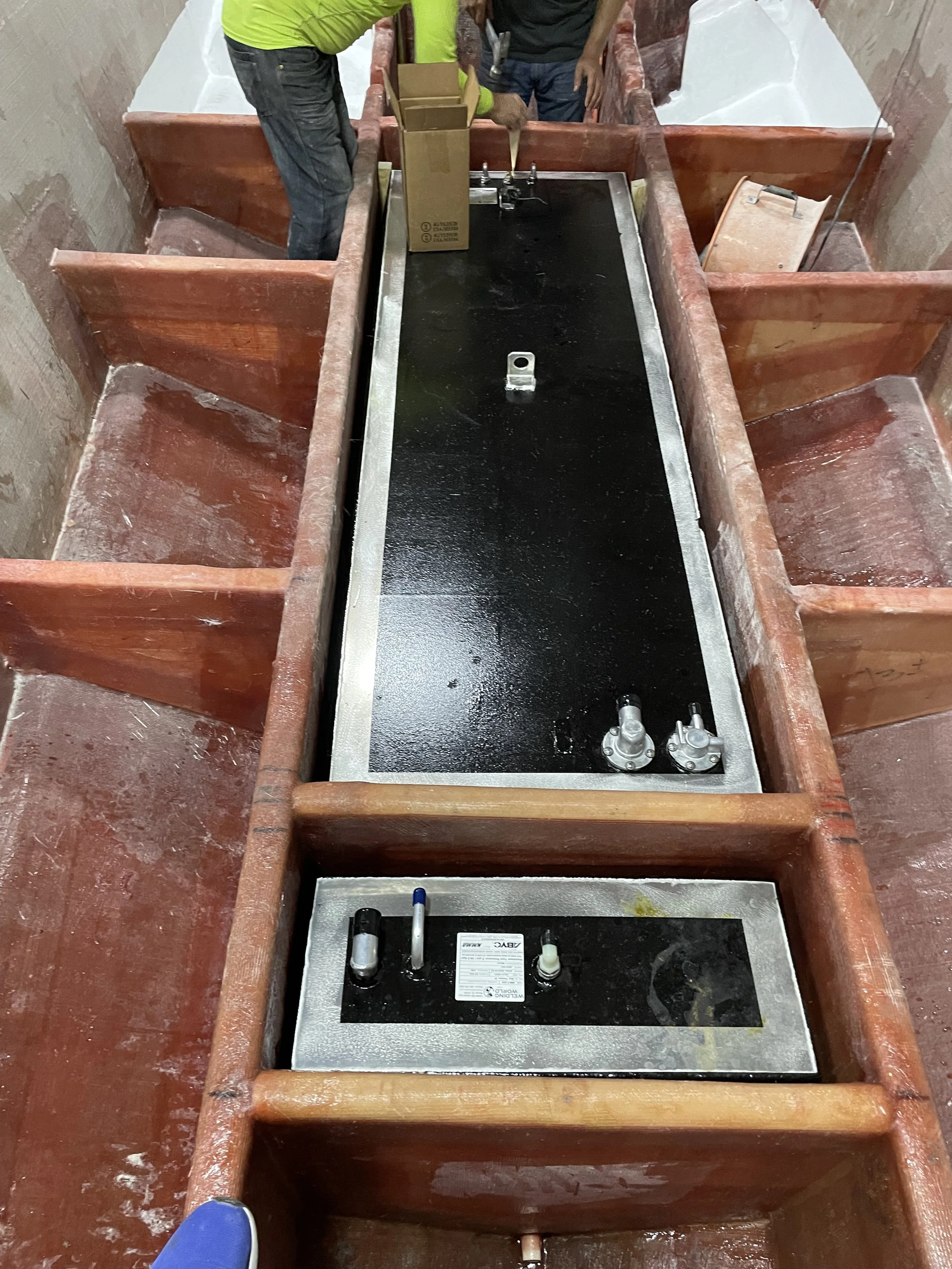 Fuel and Water Tank Installation: Tanks fitted between the stringers with foam separation, before the surrounding supports receive additional fiberglass reinforcement.