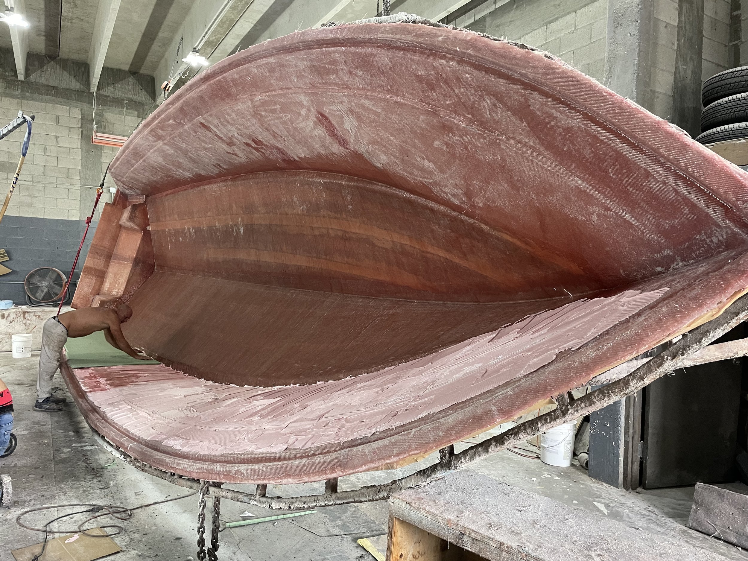 Resin Application: Resin is worked through the fiberglass fabric with attention to consistent saturation throughout the laminate.

Laminate Consolidation: Each fiberglass layer is carefully rolled to remove trapped air and bring the layers into close