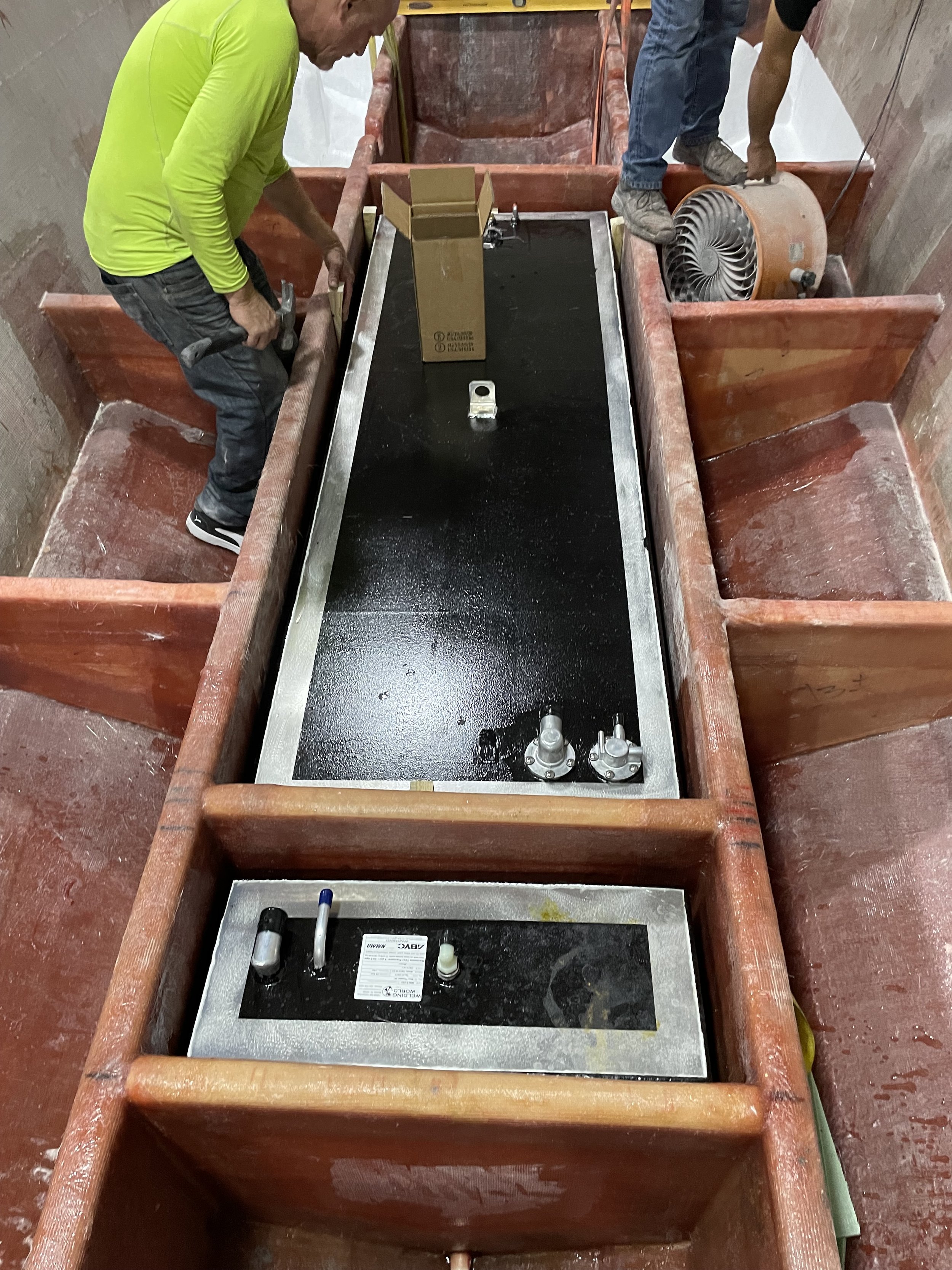 Fuel and Water Tank Installation: Tanks fitted between the stringers with foam separation, before the surrounding supports receive additional fiberglass reinforcement.