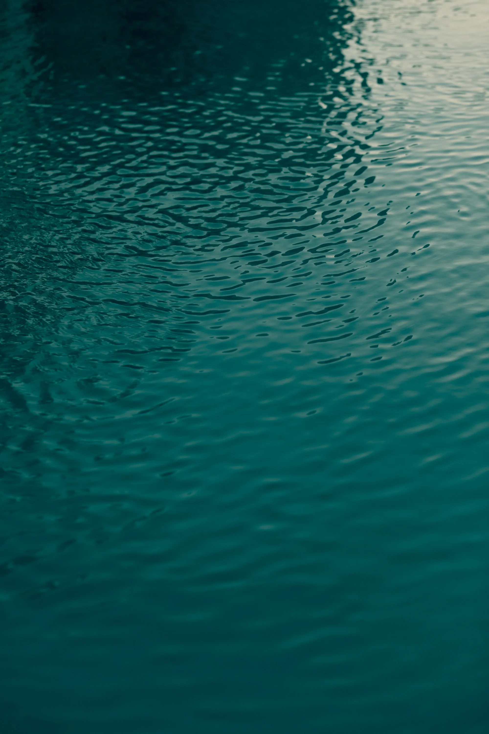 Close-up of rippling water surface in shades of blue and green.