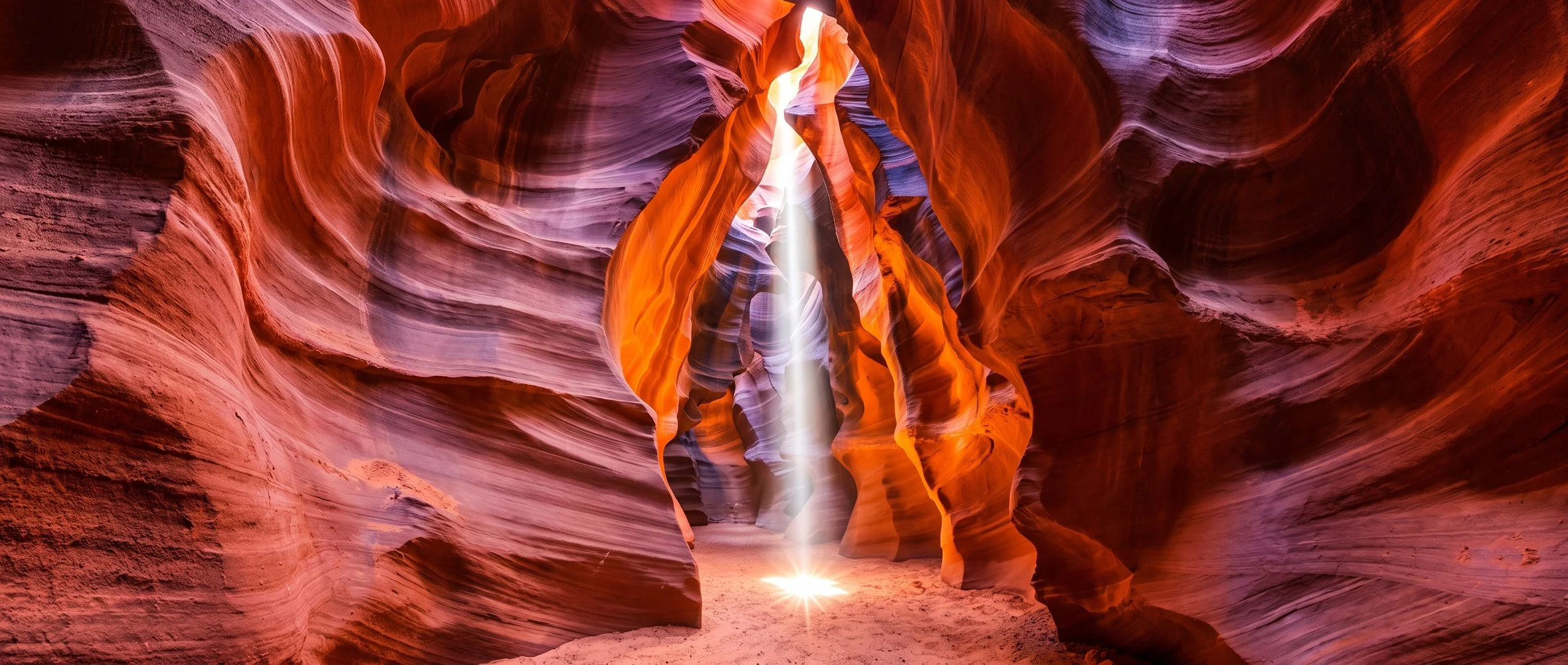 Sunlight streaming through the red and purple sandstone walls of Antelope Canyon