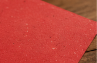 Close-up of a textured red rectangular surface on a wooden table