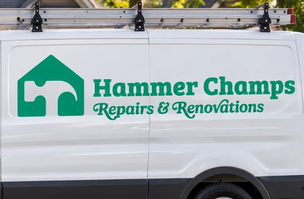 White Hammer Champs repairs and renovations service van with roof ladder rack and green hammer logo
