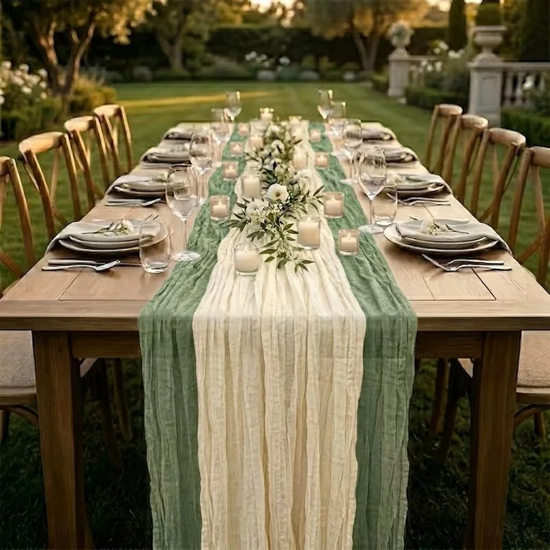 Outdoor dining table set for a formal event with plates, glasses, candles, and floral arrangements, surrounded by wooden chairs on a manicured lawn.