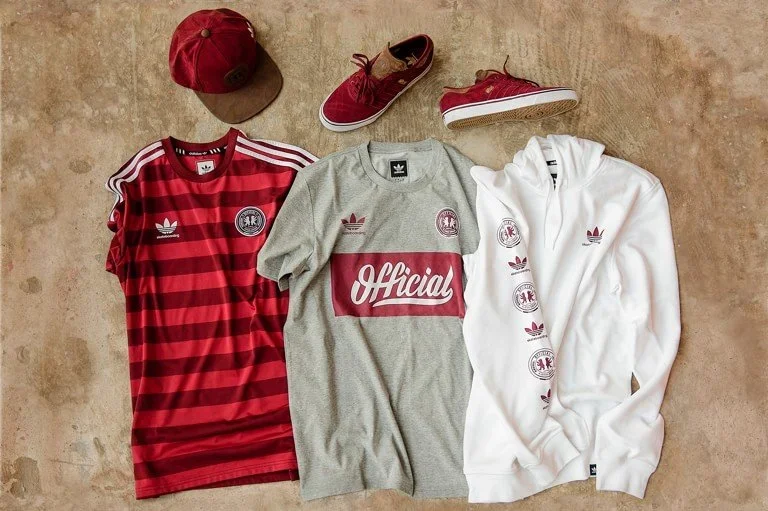Collection of red and white Adidas apparel and accessories including a red cap, red sneakers, a red and black striped soccer jersey, a grey and red 'Official' t-shirt, and a white hoodie with Adidas graphics.