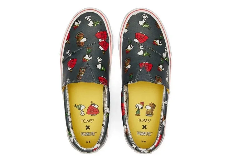Pair of TOMS slip-on shoes featuring Peanuts characters, Snoopy and Woodstock, with Peanuts-themed insoles.