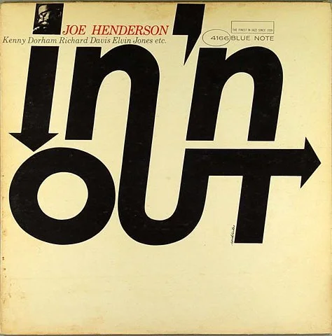 A vintage record album cover for Joe Henderson's jazz album titled "In 'n Out," featuring large black text spelling "in" and "out" with arrow elements, on a light background. The top left corner has red text with the artist's name and other musicians
