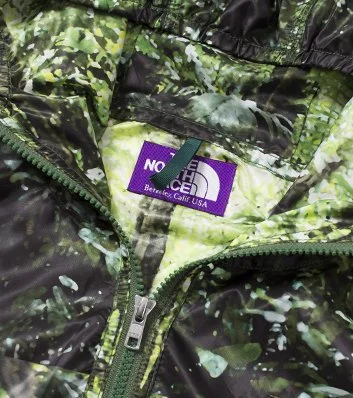 Close-up of a camouflage patterned North Face jacket with a purple label that says 'North Face, Berkeley Calif USA'.