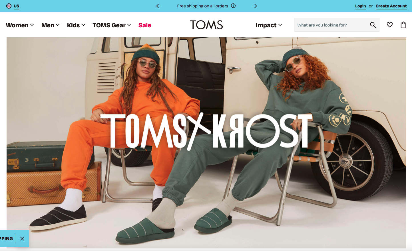 Two women wearing casual outfits and sunglasses sit in front of a vintage van, with one in an orange tracksuit and the other in a green tracksuit and slippers, for a TOMS x KROST fashion promotion.