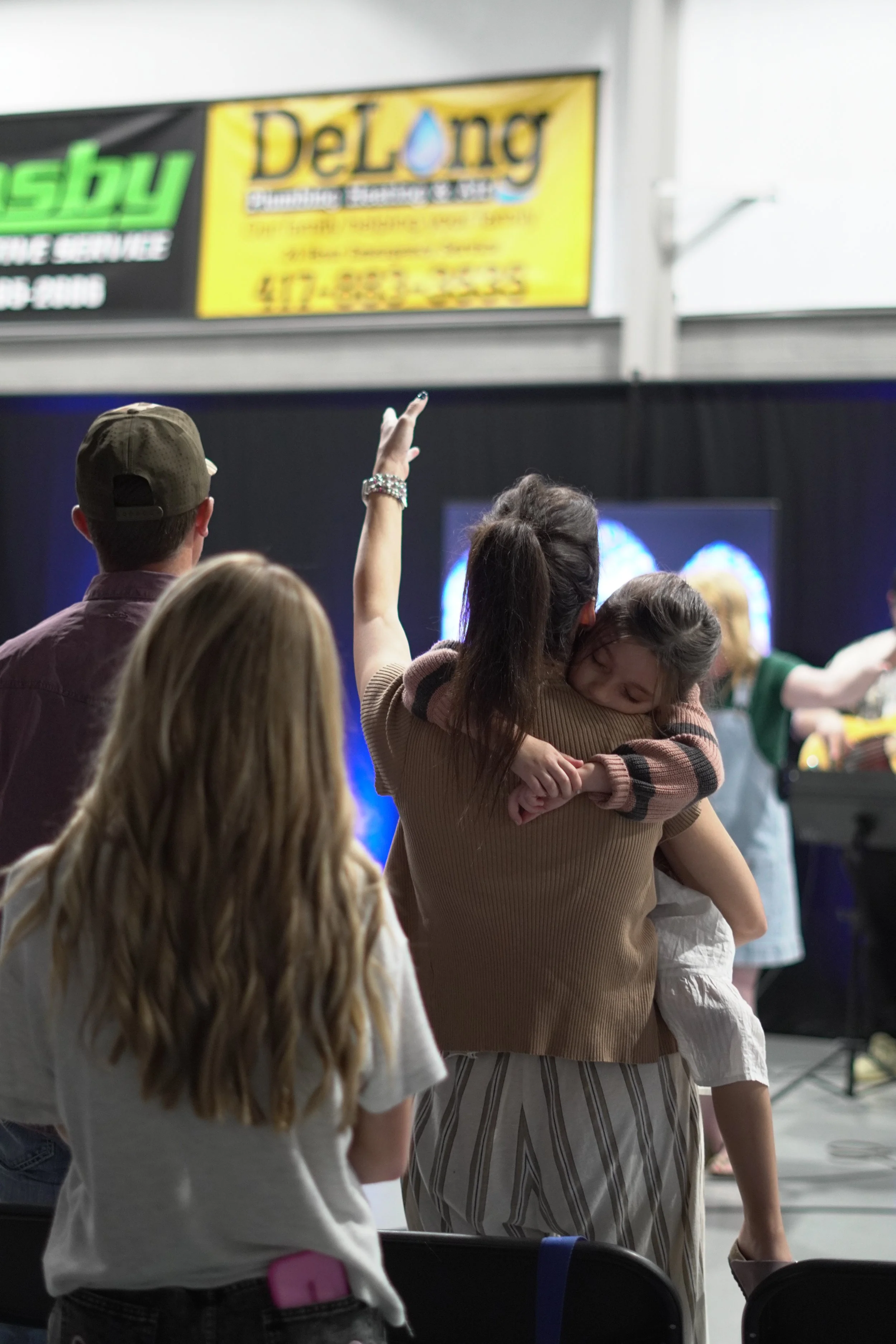 People welcoming one another and sharing a hug at a 417 Church gathering.