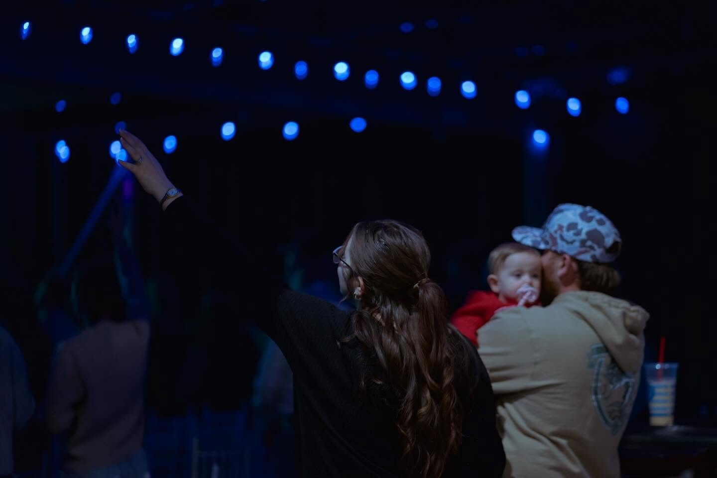 People raising their hands in worship during a 417 Church service.