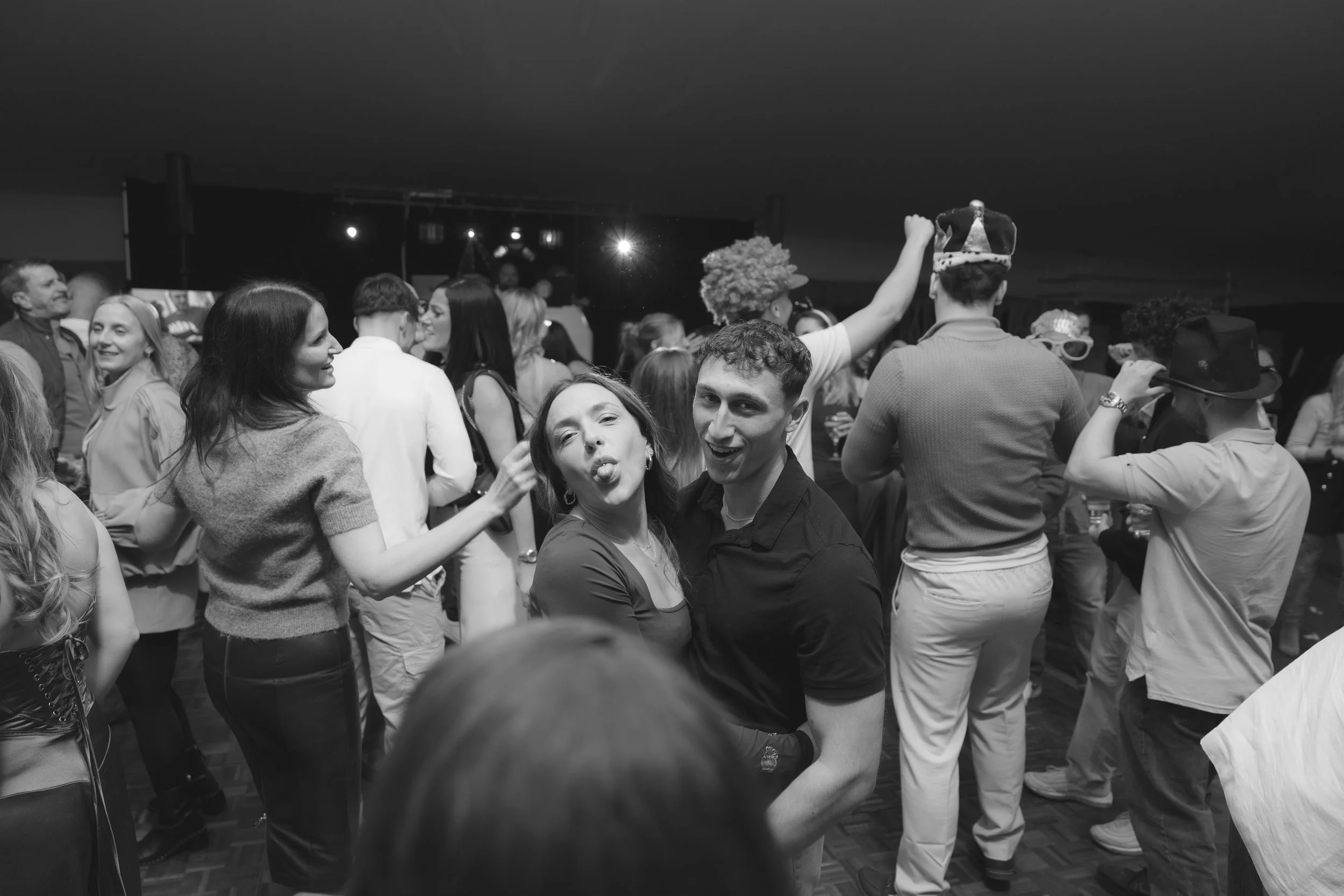 People dancing and socializing at a party with some wearing costumes and accessories.