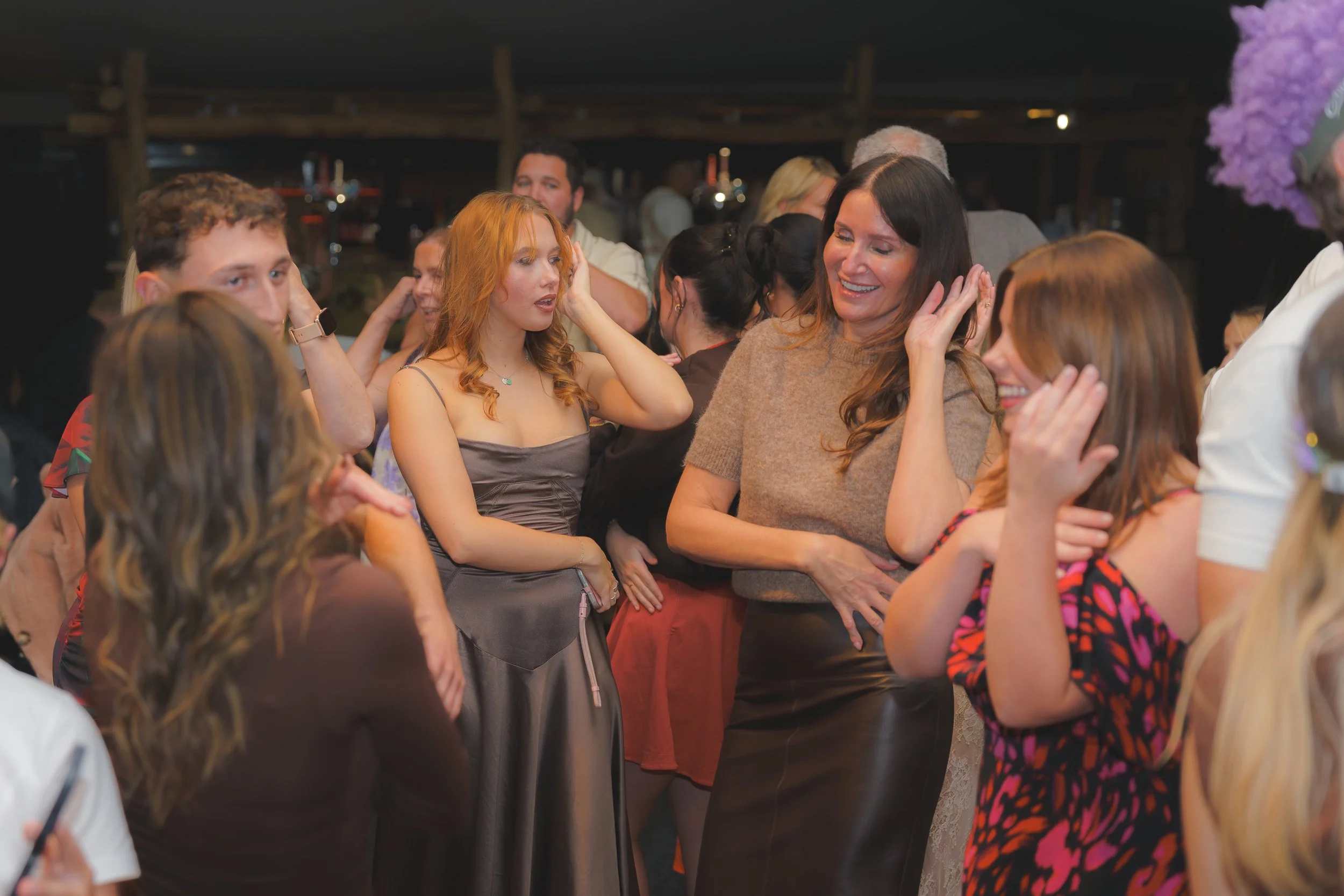 Group of people at a social gathering, engaging in conversations and smiling.