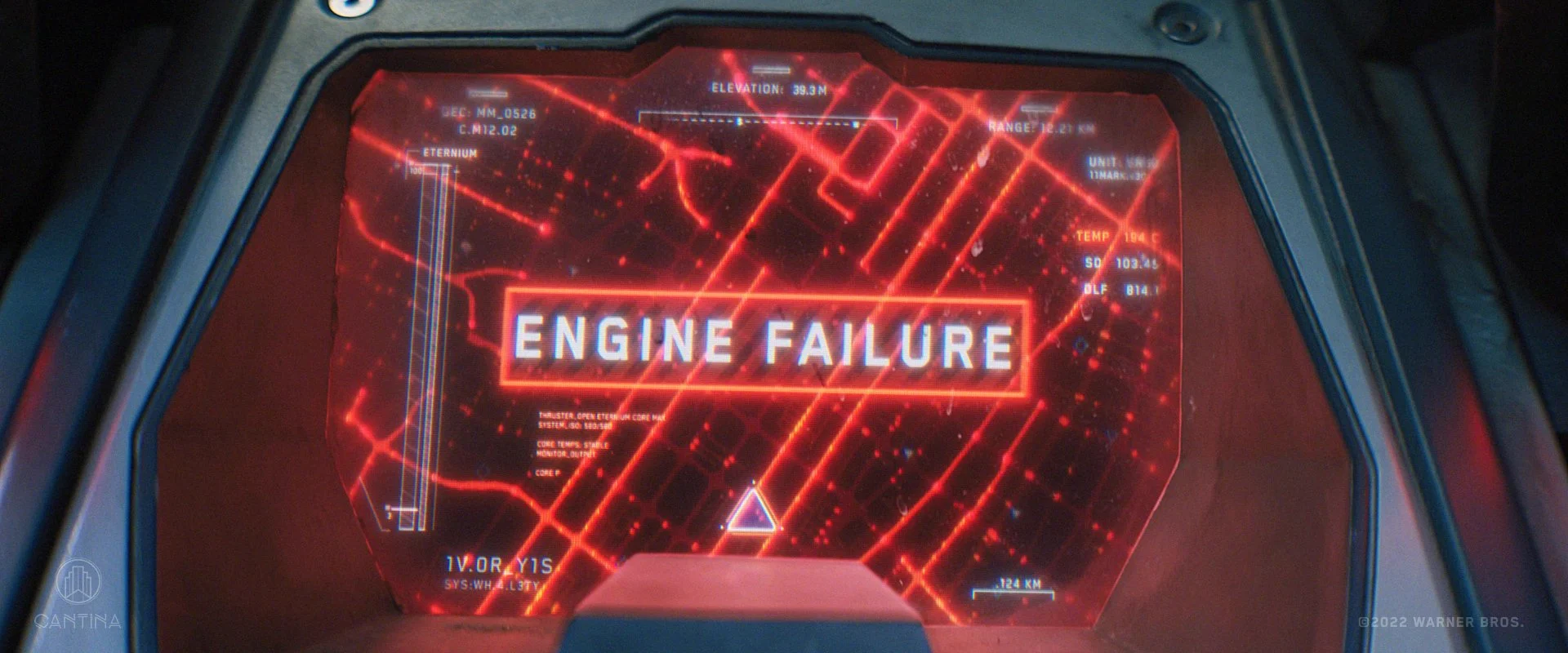 A digital display screen inside a spaceship cockpit showing the message 'ENGINE FAILURE' in bold white letters with a red background and red digital graphics, along with various technical data and coordinates. From DC's Black Adam film