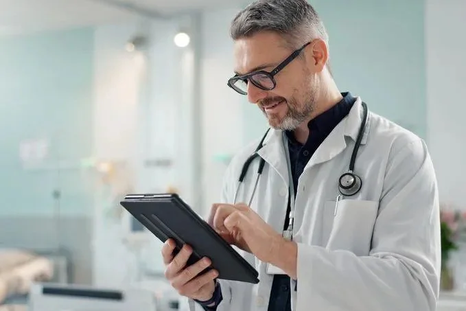 A physician reviewing patient data on a tablet