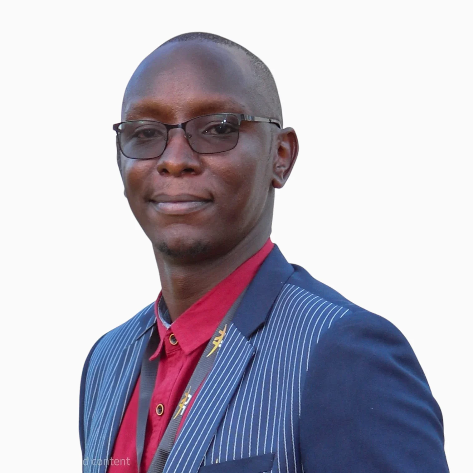 A young man with dark skin, short hair, glasses, wearing a blue pinstripe suit with a red shirt underneath, posing against a plain white background.