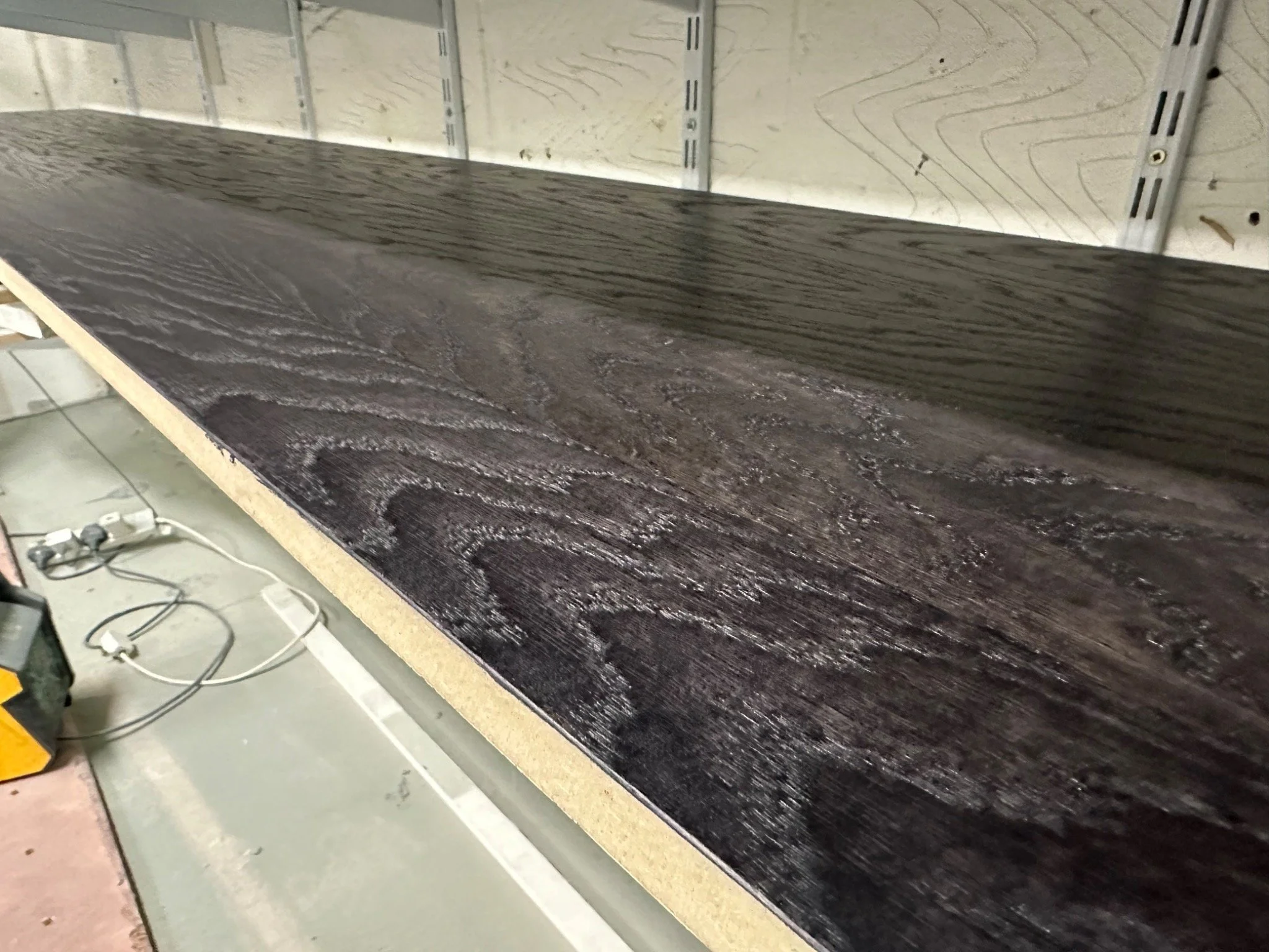 Wood staining & lacquering — dark stained timber with the natural grain visible across the finished surface. Kemispray, West London.