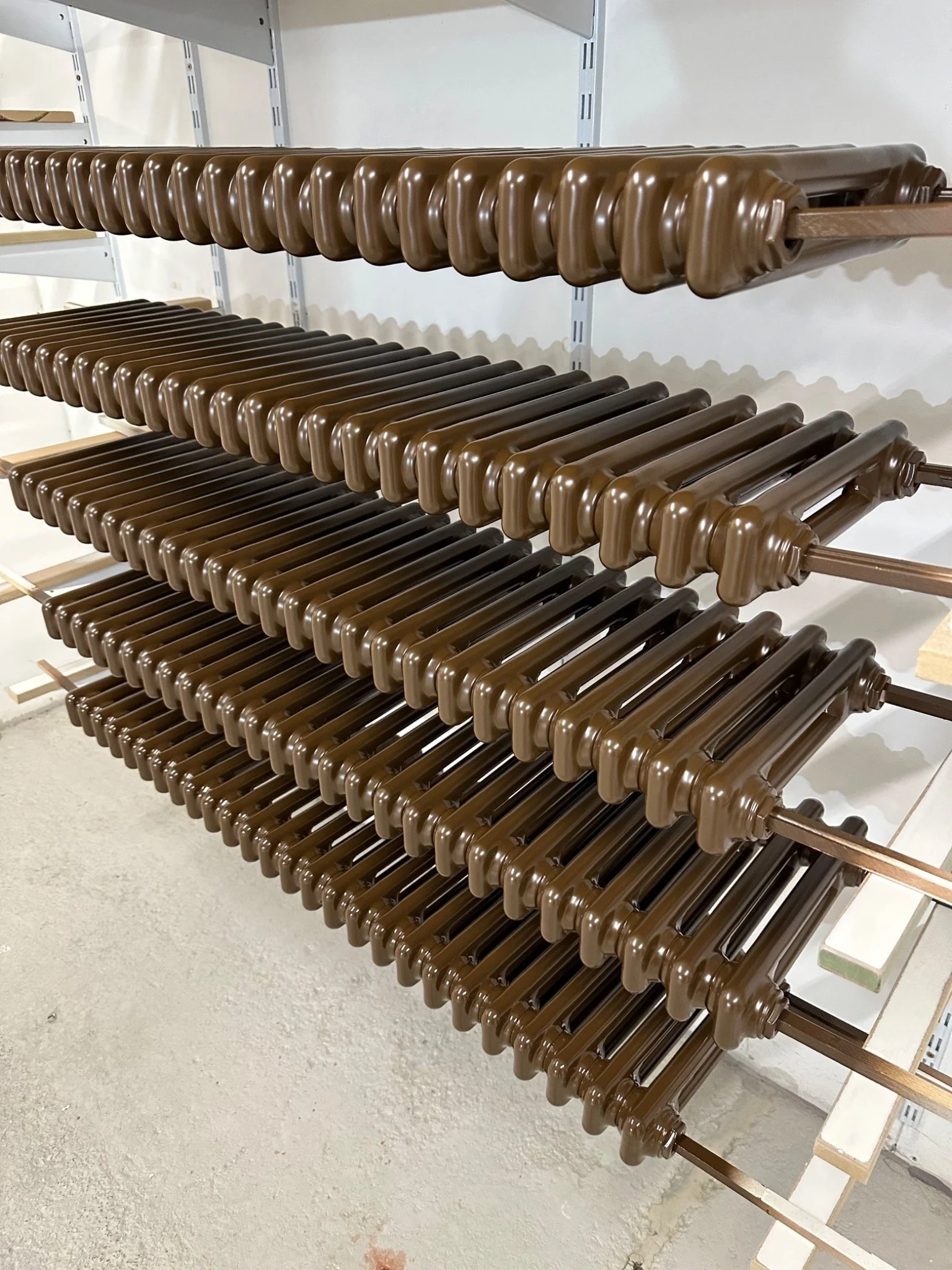 Radiator spray painting — a batch of column radiators with a consistent brown sprayed finish. Kemispray, Brentford, West London.