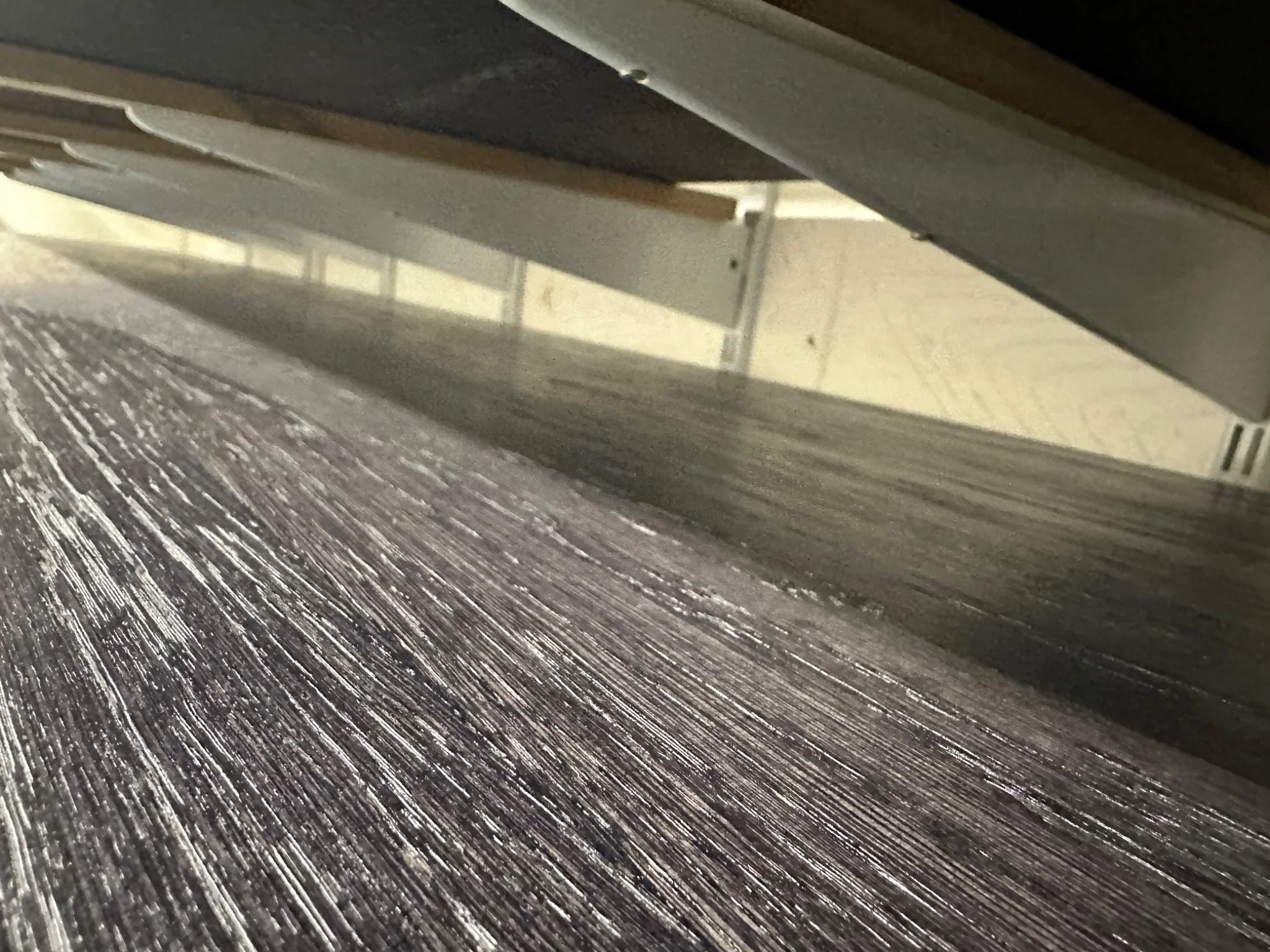 Stained and lacquered wood — close-up of the grain and dark finish from a Kemispray project in Brentford, West London.