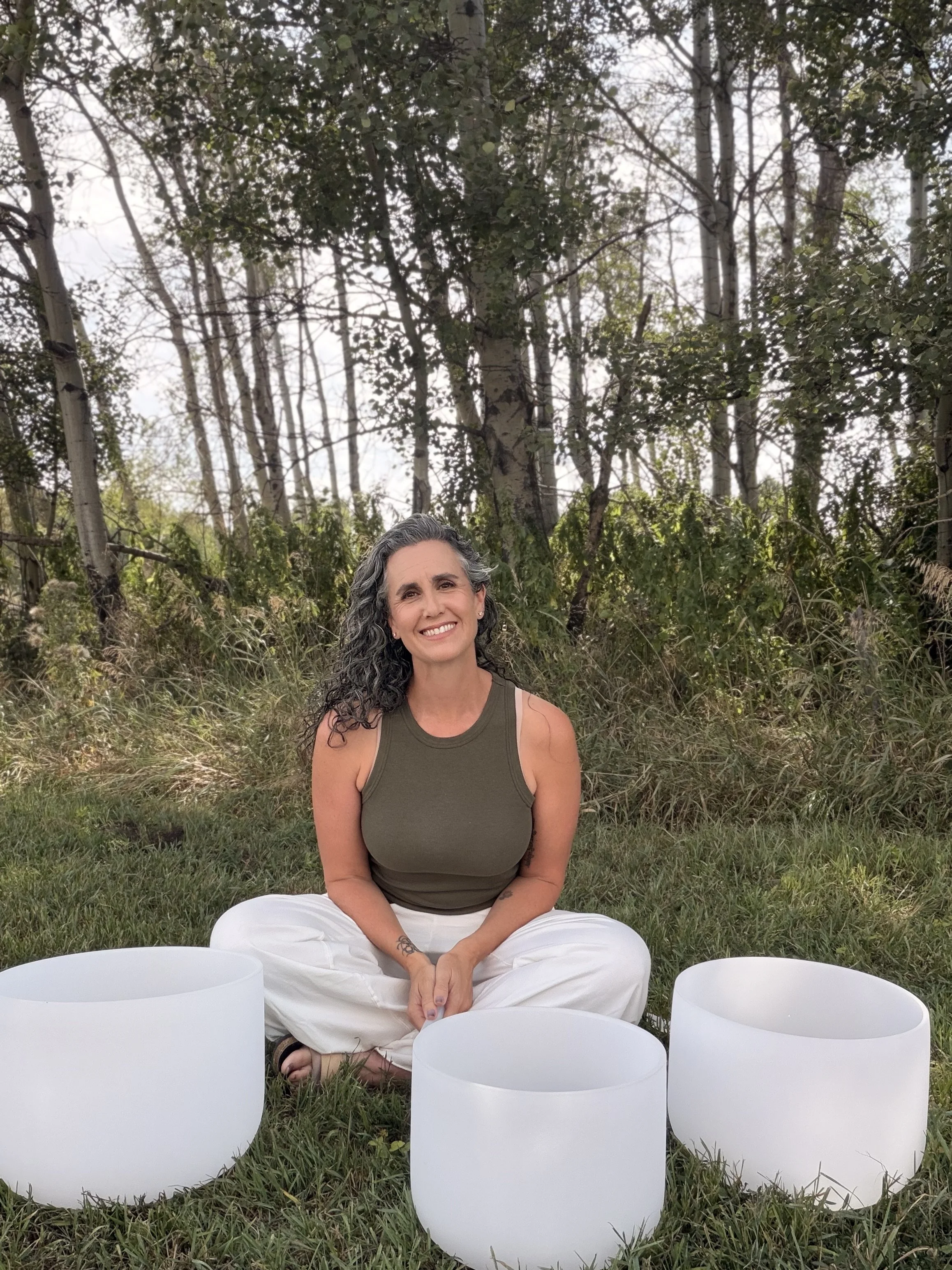 Alana, Shakti-certified sound healer and yin yoga teacher, with crystal singing bowls