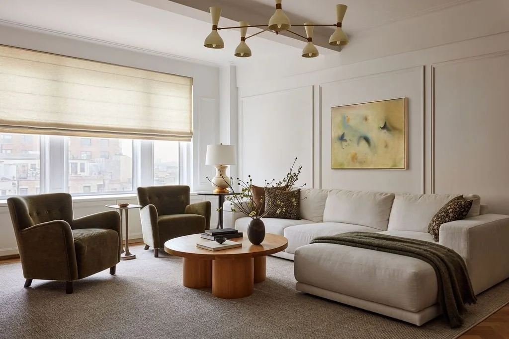Layered living room with curved seating, warm wood and soft textiles.