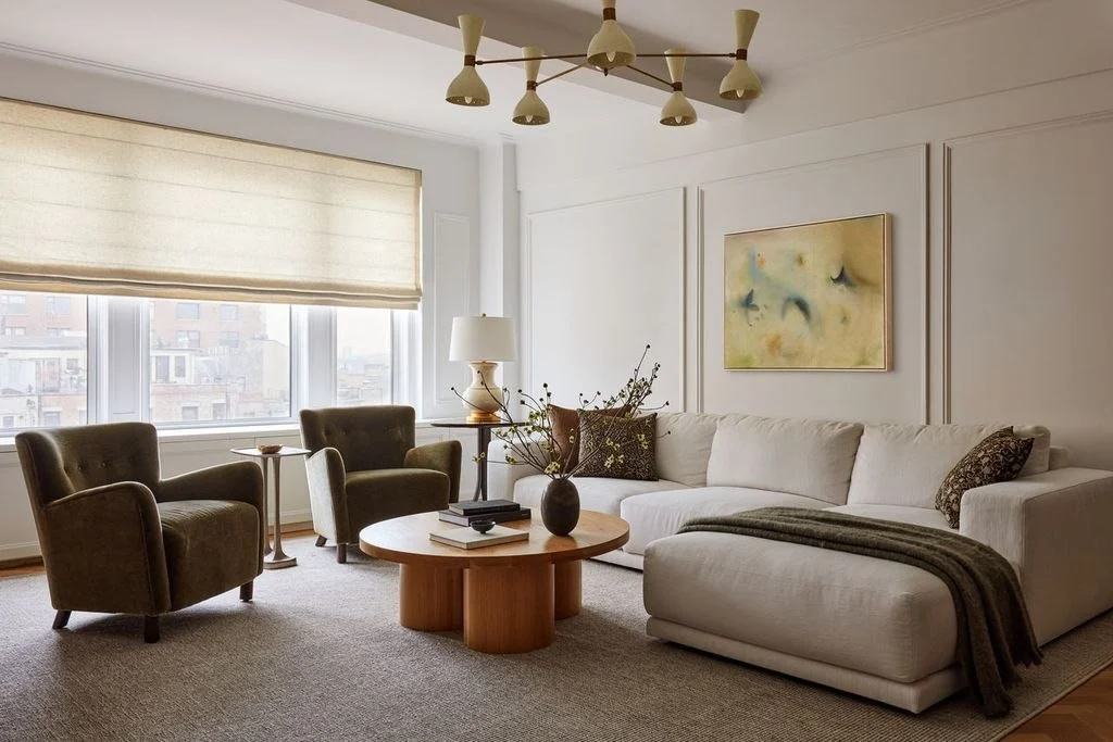Riverside Drive living room with curved seating, a warm wood coffee table, contemporary lighting and layered textiles.