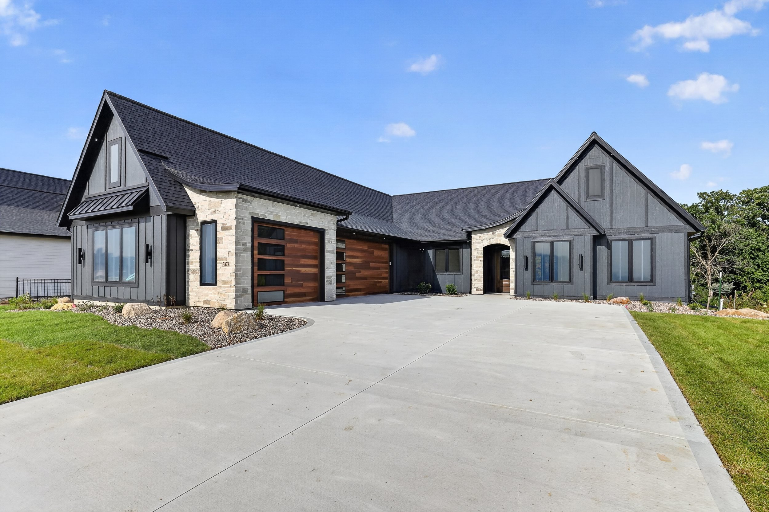 Modern charcoal home with stone accents and cedar garage doors photographed in Southeast Minnesota