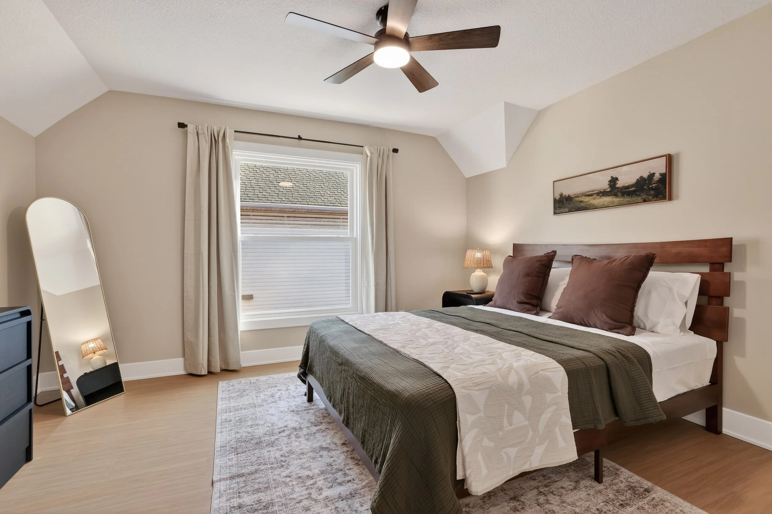 Bedroom with vaulted ceiling and neutral decor